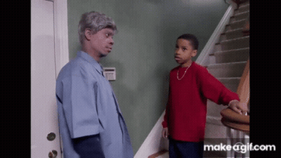 A Boy In A Red Sweater Is Standing Next To A Man In A Blue Shirt GIF
