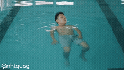 A Boy Is Floating In A Swimming Pool With The Hashtag @Nhtquag GIF