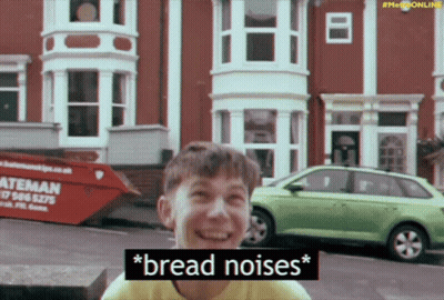 A Boy Is Laughing In Front Of A Dumpster That Says " Bread Noises " On It GIF