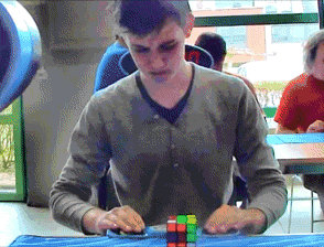 A Boy Is Playing A Game Of Rubik 'S Cube GIF