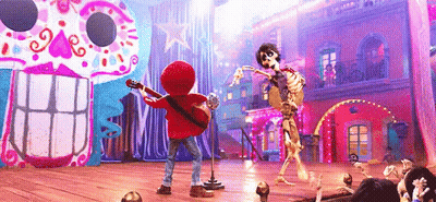 A Boy Is Playing A Guitar And Singing Into A Microphone While A Skeleton Is Dancing On A Stage . GIF