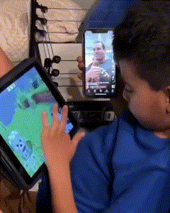 A Boy Is Playing A Video Game On A Tablet GIF
