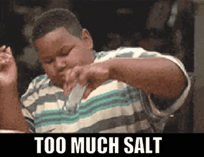 A Boy Is Pouring Salt Into His Mouth With The Words Too Much Salt Below Him GIF