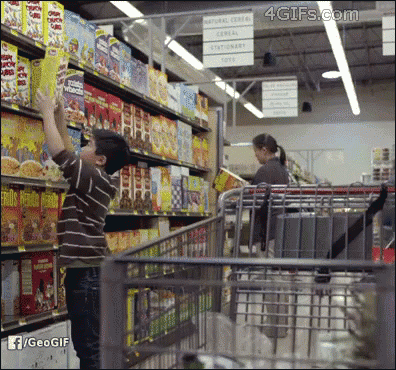 A Boy Is Reaching For A Box Of Cereal In A Store GIF