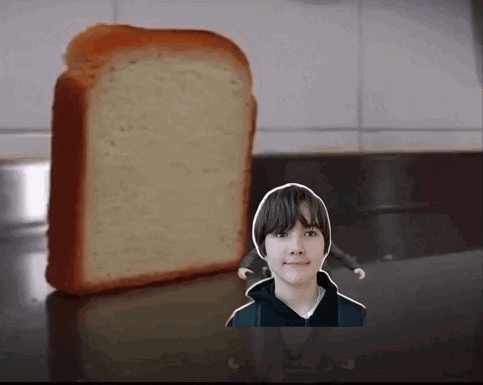 A Boy Is Standing Next To A Loaf Of Bread On A Counter GIF