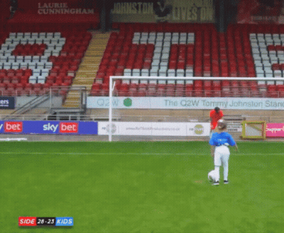 A Boy Kicking A Soccer Ball In Front Of A Sign That Says Johnston GIF