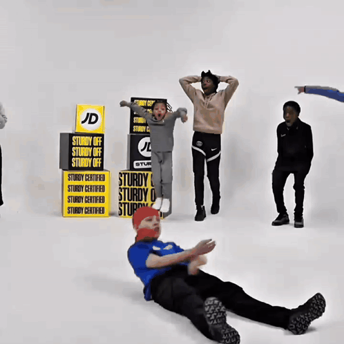 A Boy Laying On The Floor In Front Of A Stack Of Sturdy Off Signs GIF