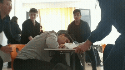 A Boy Laying On The Floor With His Head On A Book GIF
