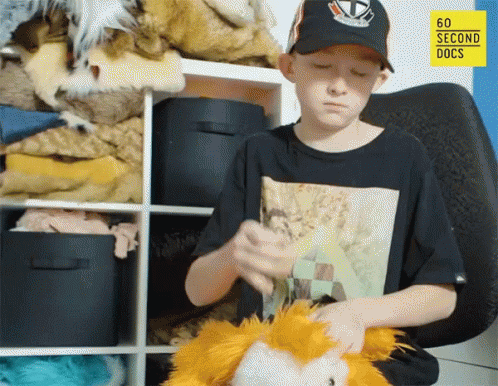 A Boy Playing With A Stuffed Animal In Front Of A 60 Second Docs Logo GIF