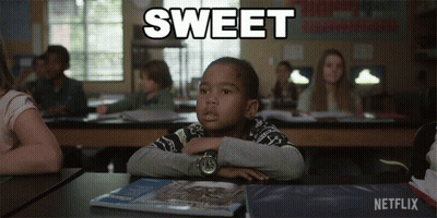 A Boy Sits At A Desk In A Classroom With The Word Sweet Written Above Him GIF