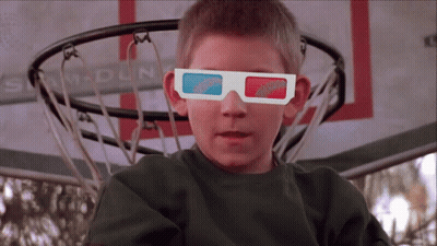 A Boy Wearing 3D Glasses Is Sitting In Front Of A Sam Dun Basketball Net GIF