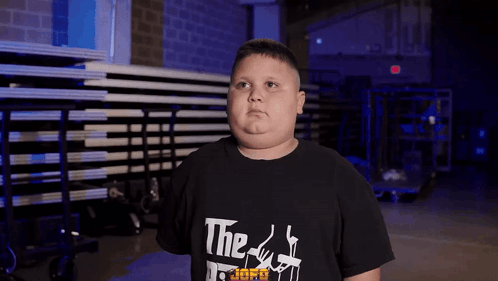 A Boy Wearing A Black T-Shirt That Says " The Godfather " GIF