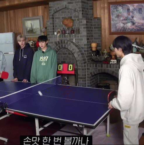 A Boy Wearing A Green 1987 Sweatshirt Is Playing Ping Pong With Two Other Boys GIF
