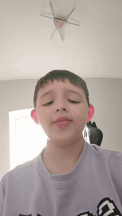 A Boy Wearing A Purple Shirt With The Letter G On It GIF