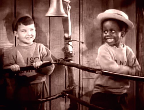 A Boy Wearing A Shirt That Says " I St " Stands Next To A Boy Wearing A Hat GIF