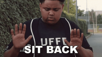 A Boy Wearing A Shirt That Says " Uff Sit Back " GIF