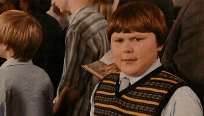 A Boy Wearing A Yellow And Black Striped Vest Looks At The Camera GIF