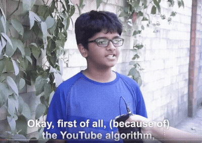 A Boy Wearing Glasses And A Blue Shirt Says Okay First Of All ( Because Of The Youtube Algorithm ) GIF