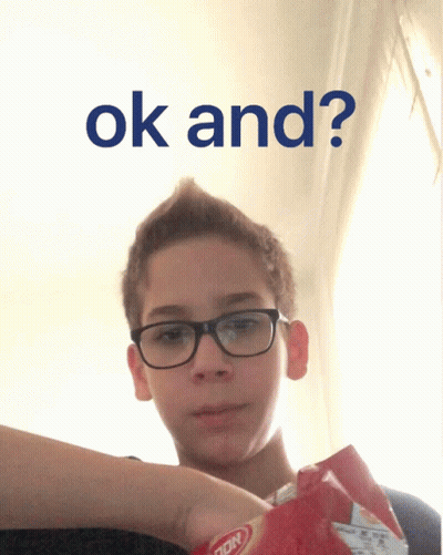 A Boy Wearing Glasses Is Holding A Bag Of Potato Chips And The Words Ok And Appear Above Him GIF