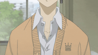 a boy with a cross earring is wearing a tan sweater