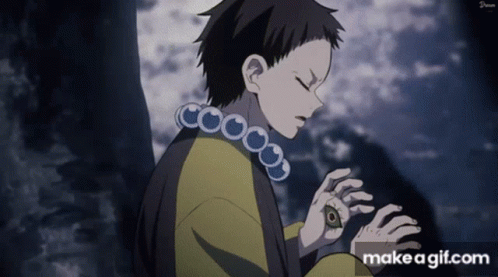 A Boy With A Necklace Around His Neck Is Looking Down At Something .. GIF