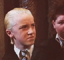 A Boy With Blonde Hair And A White Shirt And Tie GIF