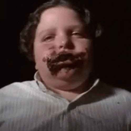 A Boy With Chocolate On His Face Is Looking At The Camera . GIF