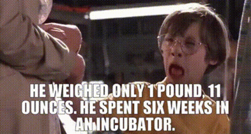 A Boy With Glasses And A Caption That Says He Weighed Only 1 Pound , 11 Ounces . GIF