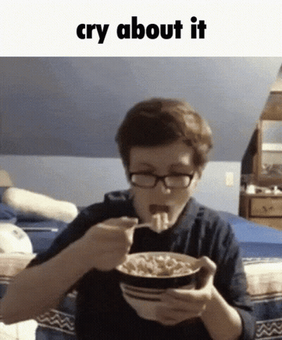 A Boy With Glasses Is Eating A Bowl Of Cereal With The Words Cry About It Above Him GIF
