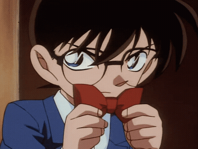 A Boy With Glasses Is Holding A Red Bow Tie In Front Of His Face GIF