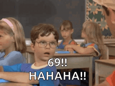 A Boy With Glasses Is Sitting At A Desk In A Classroom And Says 69 ! Hahaha !! GIF
