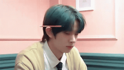 A Boy With Green Hair Is Holding A Pencil In His Hand . GIF