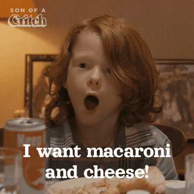 A Boy With Red Hair Is Sitting At A Table With His Mouth Open And Says " I Want Macaroni And Cheese " GIF