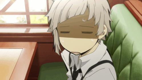 A Boy With White Hair Is Sitting In A Green Chair GIF