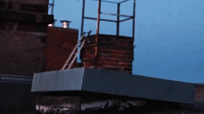 A Brick Chimney With A Ladder Going Up It GIF
