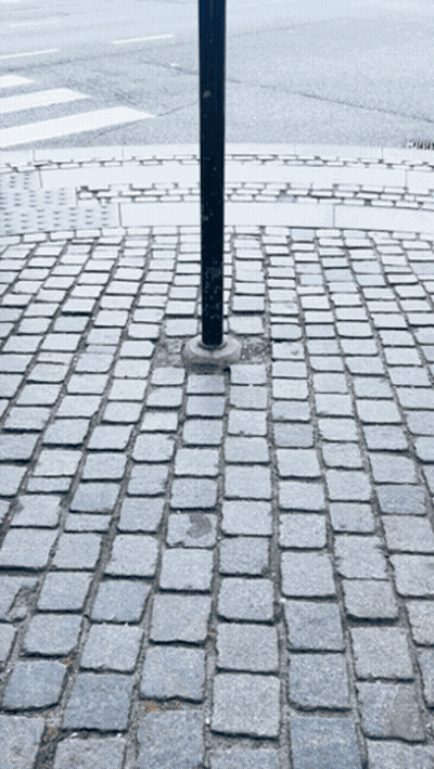 A Brick Pavement With A Pole In The Middle GIF