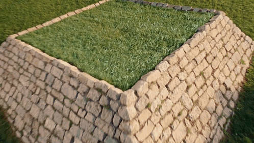 A Brick Wall With A Square Of Grass In The Middle GIF