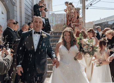 A Bride And Groom Are Being Showered With Confetti By Their Wedding Guests GIF