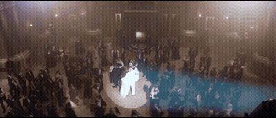 A Bride And Groom Are Dancing In Front Of A Large Crowd GIF