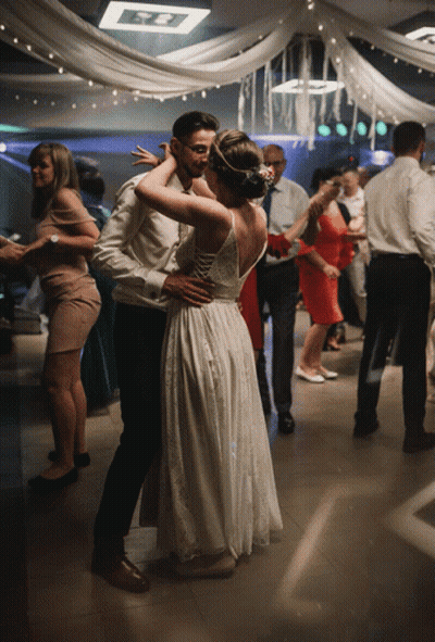 A Bride And Groom Are Dancing On A Dance Floor At A Wedding Reception GIF