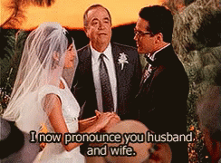 A Bride And Groom Are Getting Married And The Words I Now Pronounce You Husband And Wife Are Above Them GIF