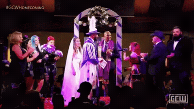 A Bride And Groom Are Getting Married In Front Of A Crowd At A Wedding . GIF