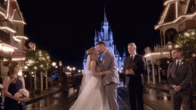 A Bride And Groom Are Kissing In Front Of A Castle GIF