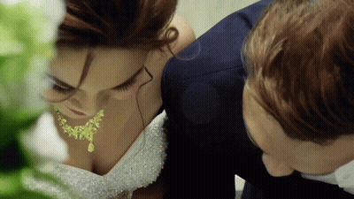 a bride and groom are looking down at each other