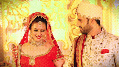 A Bride And Groom Are Posing For A Picture In Their Wedding Outfits GIF