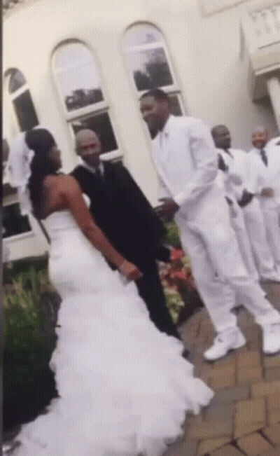 A Bride And Groom Are Posing For A Picture With Their Wedding Party GIF