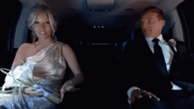 A Bride And Groom Are Sitting In A Car And The Bride Is Holding A Bouquet Of Flowers GIF