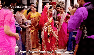 A Bride And Groom Are Standing In Front Of A Crowd Of People . GIF