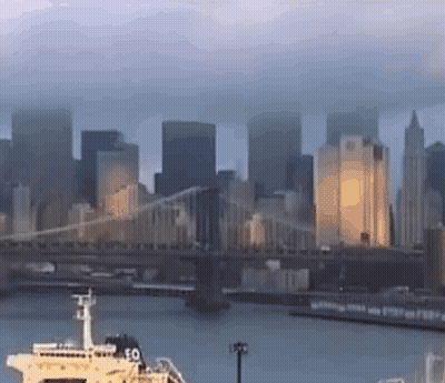 A Bridge Over A Body Of Water With A Boat In The Foreground GIF