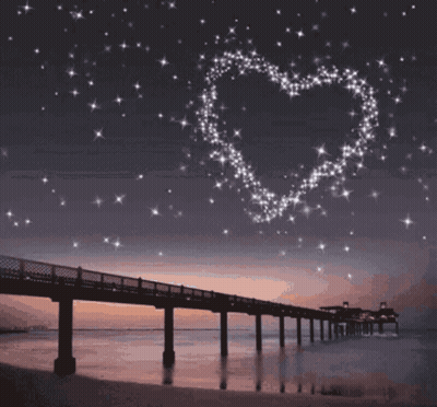 A Bridge Over A Body Of Water With A Heart Made Of Stars Above It GIF